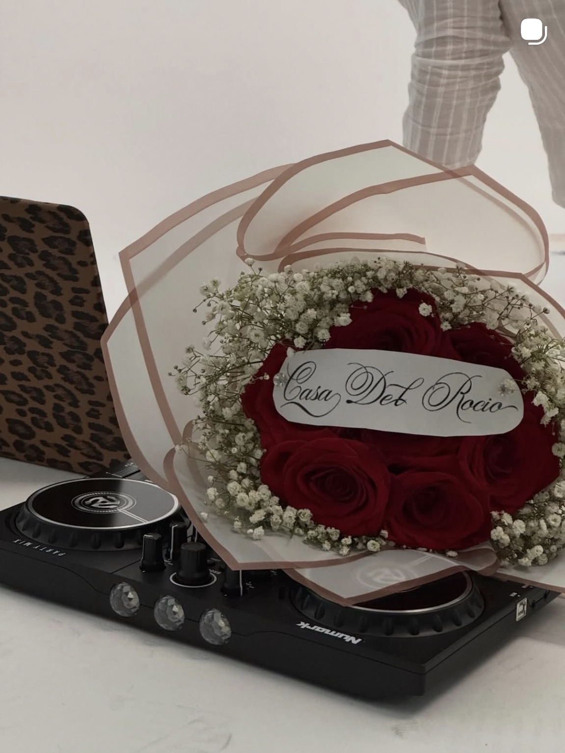 Casa del Rocío launch atmosphere — red roses with the Casa del Rocío script label beside a Numark DJ controller